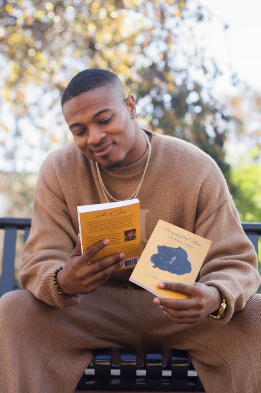 Dontez X. James holding copies of his books during an outdoor author photoshoot.